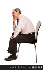 worried mature businessman on a chair, isolated on white