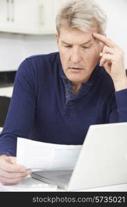 Worried Mature Man Looking Reviewing Finances At Home