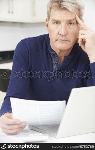 Worried Mature Man Looking Reviewing Finances At Home