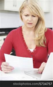 Worried Mature Woman Looking Reviewing Finances At Home