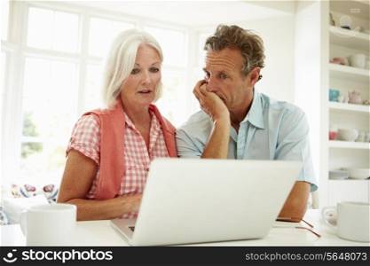 Worried Middle Aged Couple Looking At Laptop