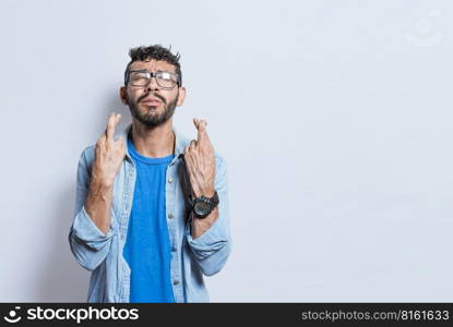 Worried person crossing his fingers making a wish, concerned man apologizing, hopeful man asking for help or apologizing, superstitious man crossing his fingers asking for something