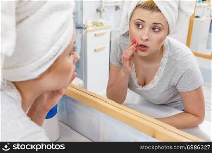 Worried shocked woman looking at her reflection in mirror thinking about her complexes having serious face expression, analyzing face skin complexion.. Woman looking at her reflection in mirror