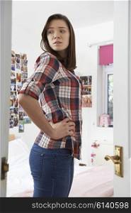 Worried Teenage Girl Looking At reflection In Bedroom Mirror