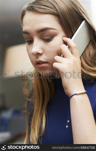 Worried Teenage Girl Making Call On Mobile Phone