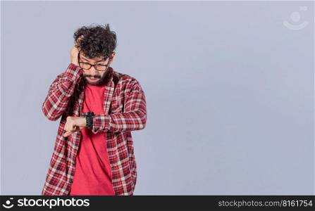 Worried young man looking at the time on the clock, worried man looking at his watch, scared man looking at his watch, isolated