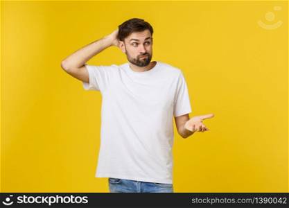 Worried young man standing isolate on yellow wall.. Worried young man standing isolate on yellow wall