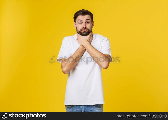 Worried young man standing isolate on yellow wall.. Worried young man standing isolate on yellow wall