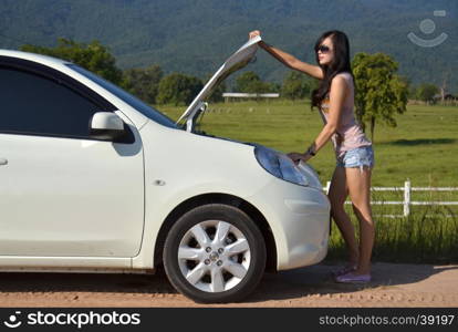 Worried young woman with her broken car