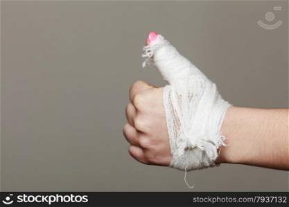 wounded female hand tied elastic bandage, human injury finger on gray background