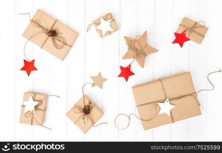 Wrapped gift boxes with decoration on bright wooden background. Holidays flat lay