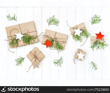 Wrapped gifts with christmas decoration on bright wooden background. Flat lay