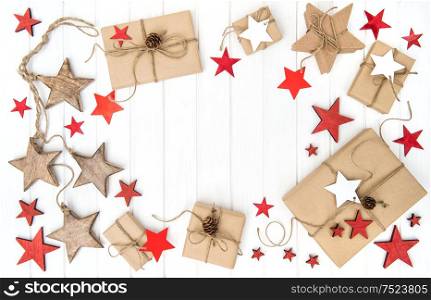 Wrapped gifts with christmas decoration red stars on bright wooden background. Flat lay