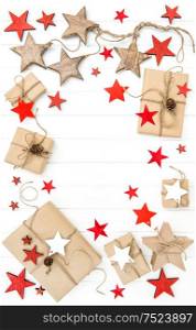 Wrapped gifts with red stars decoration on bright wooden background. Flat lay
