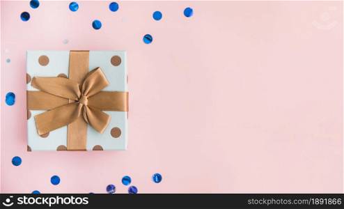 wrapped present with brown bow and ribbon on pastel pink backdrop. Resolution and high quality beautiful photo. wrapped present with brown bow and ribbon on pastel pink backdrop. High quality and resolution beautiful photo concept