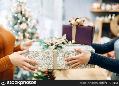 Wrapping service seller gives to customer christmas gift box. Buyer ordered a package of present. Wrapping service seller gives to customer gift box