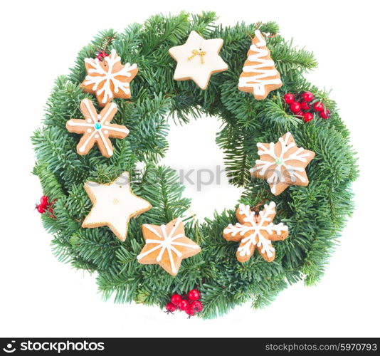 wreath decorated with christmas cookies. Evergreen fir tree wreath decorated with christmas gigngerbread cookies isolated on white background