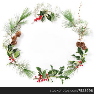 Wreath from pine tree branches with ilex leaves on white background. Christmas flat lay