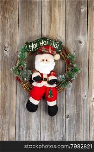 Wreath with Santa Claus symbol on rustic wood. Layout in vertical format.
