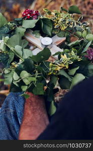 Wreaths of flowers and herbs. Man taking a wreath from a river. Midsummer divination