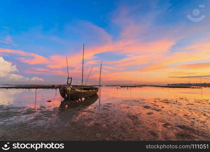 Wrecked fishing boat at sea with sunrise