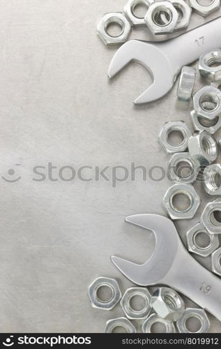 wrench and nut tool on metal background texture