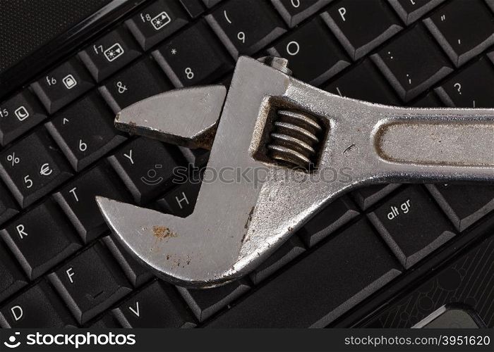 wrench tool over a laptop, repair service concept