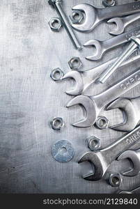 Wrench with nuts and bolts. On a gray background. High quality photo. Wrench with nuts and bolts.