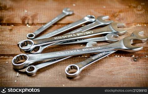 Wrenches with nuts on the table. On a wooden background. High quality photo. Wrenches with nuts on the table.