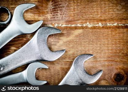 Wrenches with nuts on the table. On a wooden background. High quality photo. Wrenches with nuts on the table.