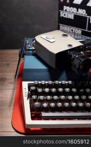 writer or screenwriter concept from vintage retro typewriter, film camera and movie clapper board at table