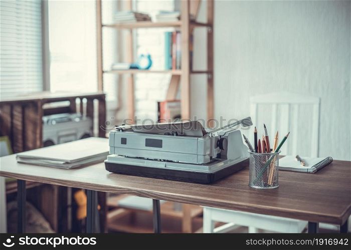 Writer or screenwriter creative concept. Notebook and vintage old typewriter at wooden desk table