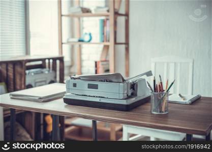 Writer or screenwriter creative concept. Notebook and vintage old typewriter at wooden desk table