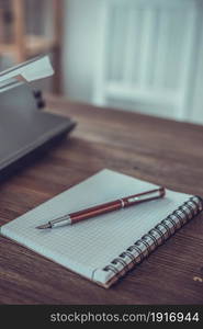 Writer or screenwriter creative concept. Notebook and vintage old typewriter at wooden desk table