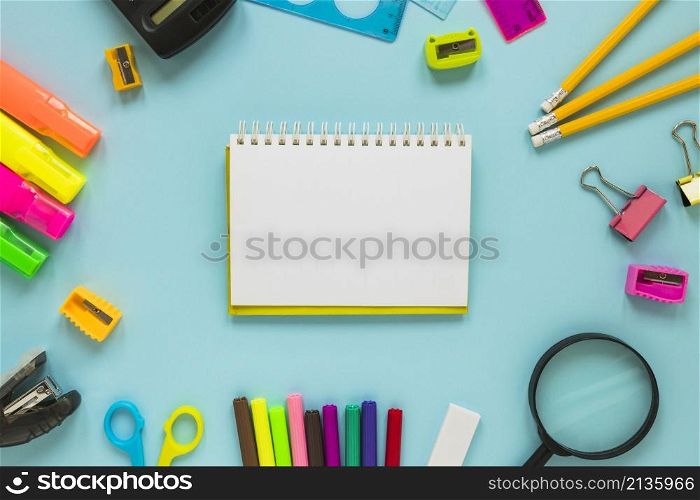 writing implements laid circle with jotter middle