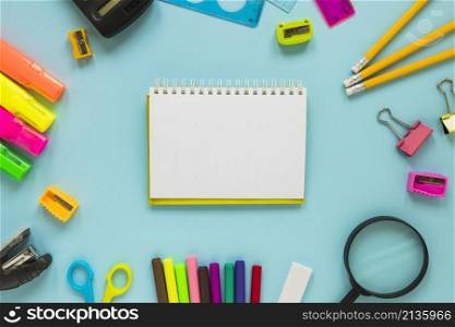 writing implements laid circle with jotter middle