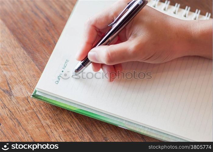 Writing important note on spiral notebook, stock photo