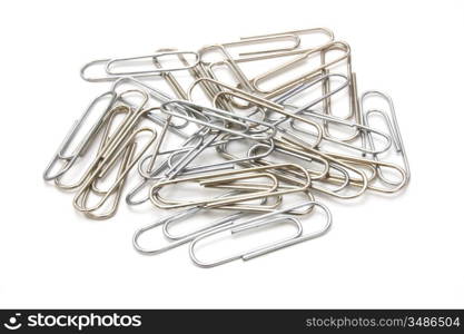 Writing metal paper clips lie in bulk on a white background of a paper