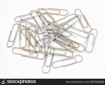 Writing metal paper clips lie in bulk on a white background of a paper