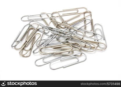 Writing metal paper clips lie in bulk on a white background of a paper