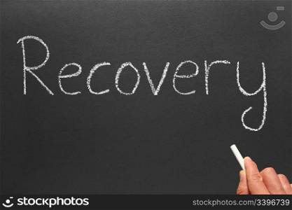 Writing the word recovery on a blackboard.