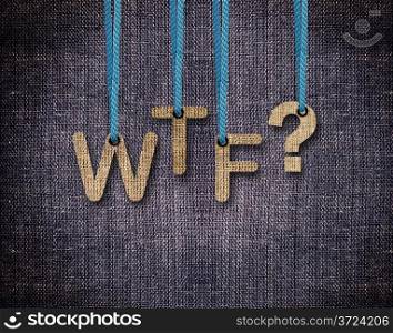 WTF Letters hanging strings with blue sackcloth background.. WTF