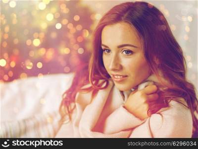 x-mas, winter holidays and people concept - happy young woman with plaid over christmas tree at home. happy young woman with plaid at home for christmas