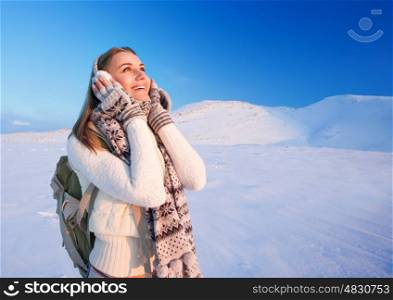 &#xA;Cute excited girl holding head by hands with wonder looking up, enjoying beautiful winter mountains view, happy active wintertime holidays