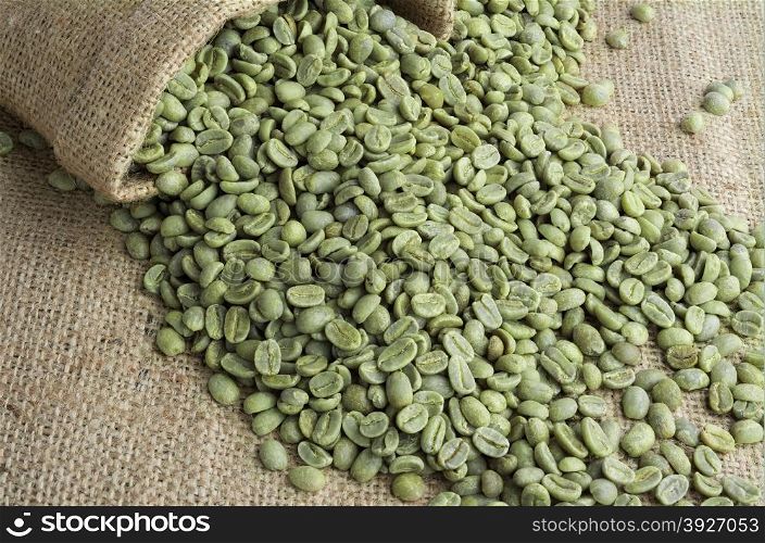 &#xA;Green coffee beans in burlap sack on burlap surface