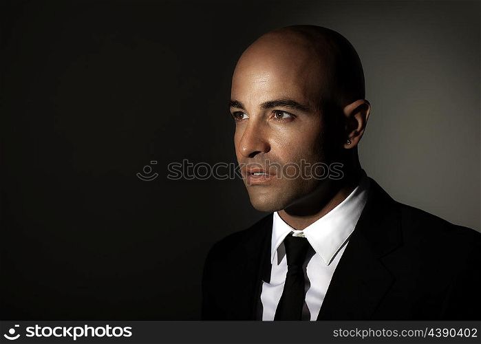 &#xA;Portrait of a man wearing black suit, white shirt and stylish tie, standing over dark background with copy space, expensive outfit, fashion and business lifestyle