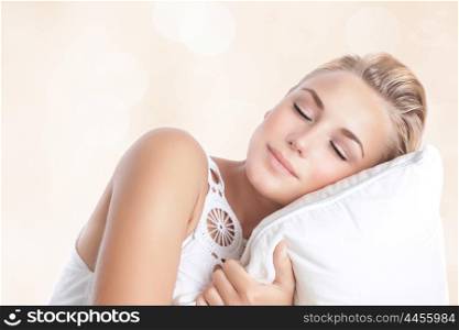 &#xA;Portrait of beautiful woman sleeping on the pillow isolated on blur beige background, happy calm day dreaming, conception of relaxation