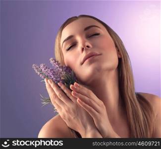 &#xA;Portrait of gentle woman with closed eyes enjoying aroma of tender lavender flowers over purple background, luxury spa salon