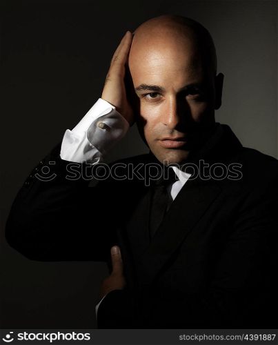 &#xA;Portrait of handsome man wearing trendy suit isolated over dark background, fashion for stylish successful young men