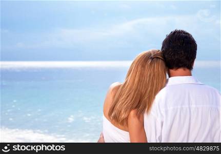 &#xA;Rear view of young couple hugging on the beach, honeymoon on Maldives, enjoying wonderful seaview, love concept&#xA;